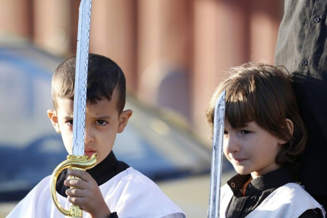 Iraqi Shi'ite Muslim boys hold toy swords as they commemorate Ashoura in Baghdad November 4, 2014. More than one million Shi'ite Muslims gathered at shrines and mosques across Iraq on Tuesday for the Ashoura religious ritual with Iraqi security forces on 
