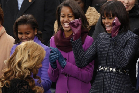 First Lady Michelle Obama (R) and her daughters Malia (C) and Sasha cheer as Beyonce returns to her seat after singing the Star Spangled Banner after the swearing-in of U.S. President Barack Obama in Washington, January 21, 2013.