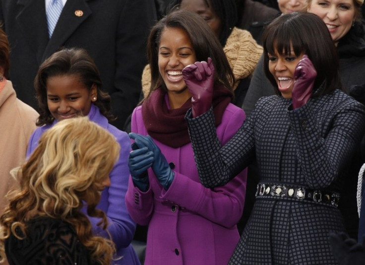 First Lady Michelle Obama (R) and her daughters Malia (C) and Sasha cheer as Beyonce returns to her seat after singing the Star Spangled Banner after the swearing-in of U.S. President Barack Obama in Washington, January 21, 2013.