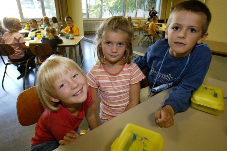 Six-year-old Pia, Paulina and Markus (LtoR) pose on their first day at the Marienfelde Klepert elementary school in Berlin August 25, 2003. German consumer protection Minister Renate Kuenast visited the school children during their first day at school and