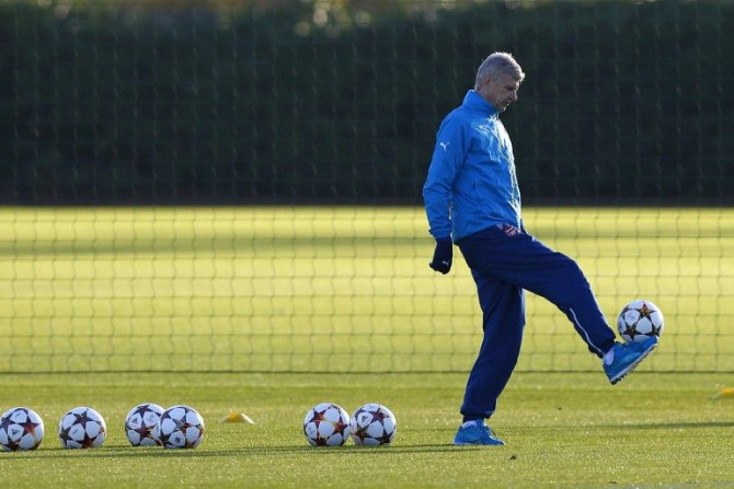 Arsenal manager Arsene Wenger controls a ball during a training session ahead of their Champions League soccer match against Galatasaray, at their training facility in London Colney, north of London December 8, 2014.