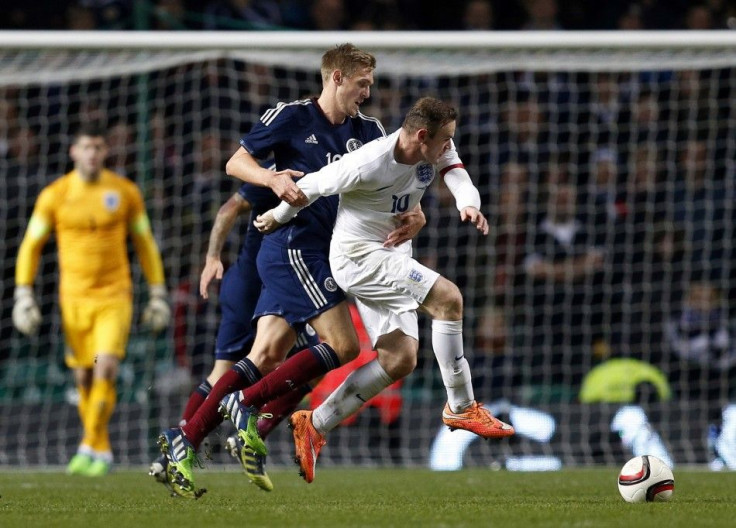 England&#039;s Wayne Rooney (R) is challenged by Scotland&#039;s Darren Fletcher during their international friendly soccer match at Celtic Park Stadium in Glasgow, Scotland November 18, 2014.