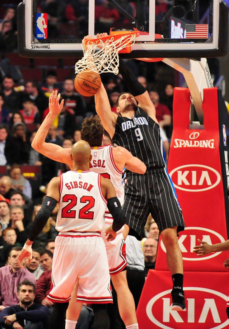 Jan 12, 2015; Chicago, IL, USA; Orlando Magic center Nikola Vucevic (9) dunks over Chicago Bulls forward Pau Gasol (16) and forward Taj Gibson (22) during the first half at the United Center.