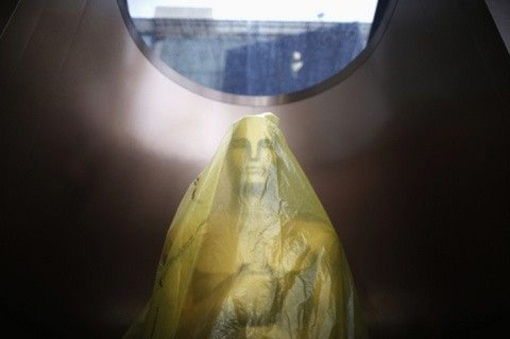 An Oscar statue is covered in plastic sheeting on the red carpet during preparations for the 86th Academy Awards in Hollywood,