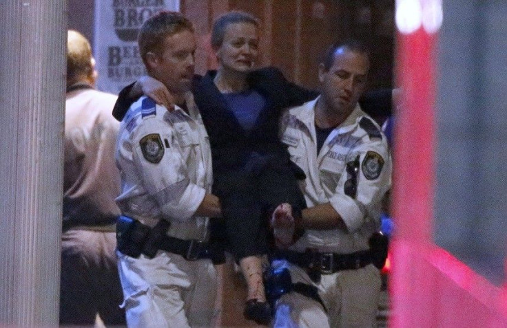 Police rescue personnel carry an injured woman from the Lindt cafe, where hostages are being held, at Martin Place in central Sydney December 16, 2014. Australian security forces on Tuesday stormed the Sydney cafe where several hostages were being held at