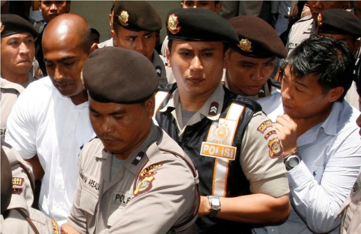 Australian Andrew Chan and Myuran Sukumaran (L) are escorted by police