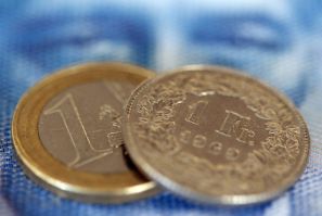 An one euro coin and an one Swiss franc coin are seen on a one hundred Swiss franc note, in this picture illustration taken in Zurich August 8, 2011. The safe-haven Swiss franc and  the yen soared on Monday after Standard