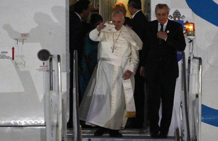 Pope Francis waves to the crowd as he disembarks from a passenger jet with an aide upon arrival at Villamor Air Base for a state and pastoral visit, in Manila January 15, 2015. Tens of thousands of people lined the streets of the Philippines capital of Ma