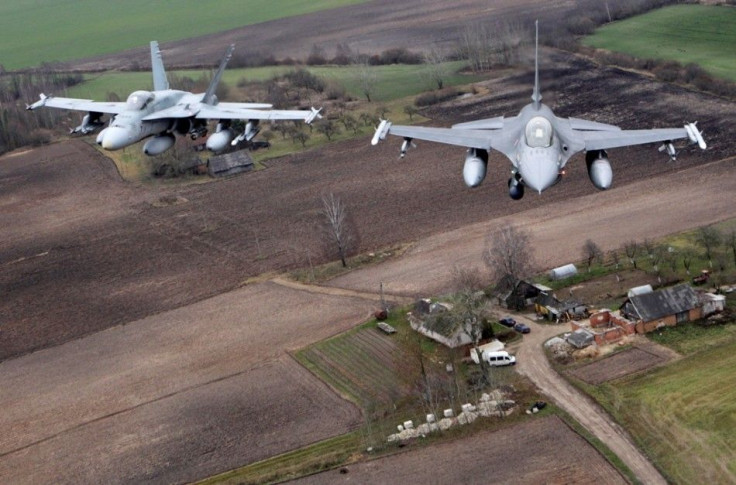 Portuguese Air Force fighter F-16 (R) and Canadian Air Force fighter CF-18 Hornet patrol over Baltics air space, from the Zokniai air base near Siauliai November 20, 2014. NATO pilots practised scrambling their jets on Wednesday, in preparation for potent