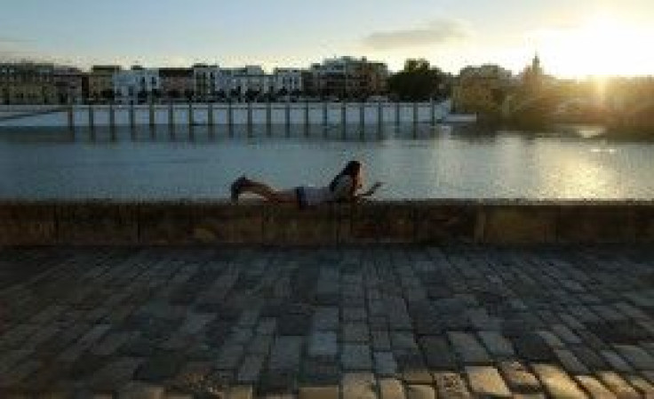 A woman reads a book at the Guadalquivir riverside in the Andalusian capital of Seville October 8, 2014.