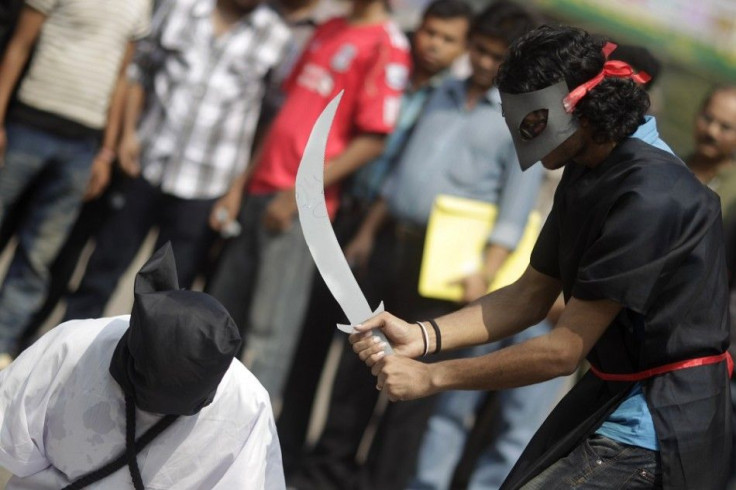 Members of Magic Movement, a group of young Bangladeshis, stage a mock execution scene in protest of Saudi Arabia beheading of eight Bangladeshi workers in front of National Museum in Dhaka October 15, 2011. Eight Bangladeshi migrants have been beheaded i