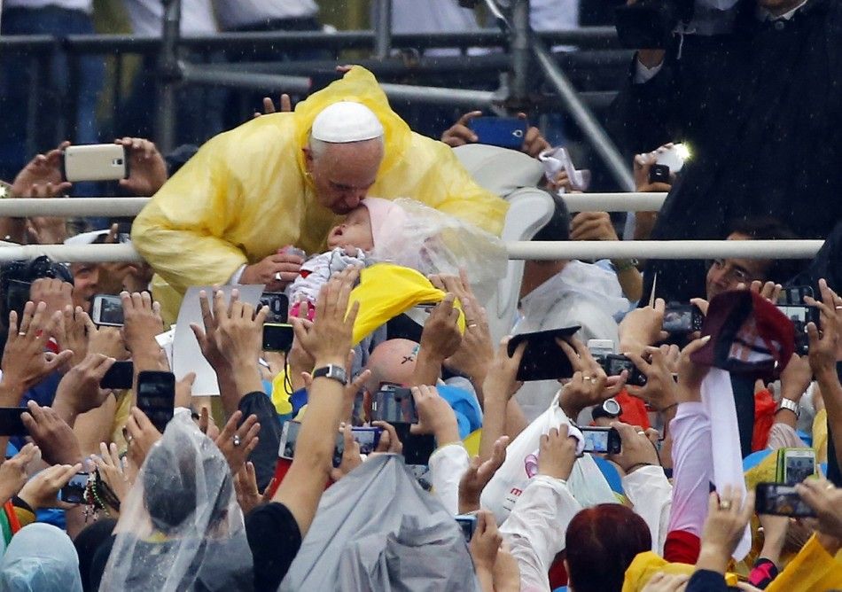 Pope Francis kisses a child as he arrives to lead an open-air Mass at Rizal Park in Manila January 18, 2015. REUTERSStefano Rellandini