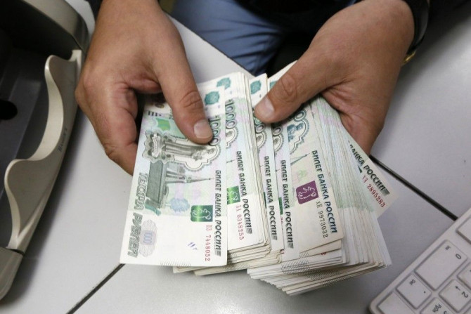 An employee counts Russian ruble banknotes