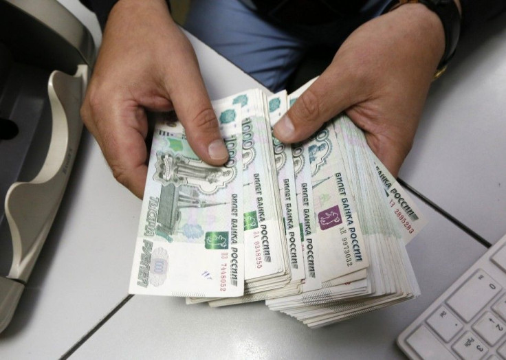 An employee counts Russian ruble banknotes