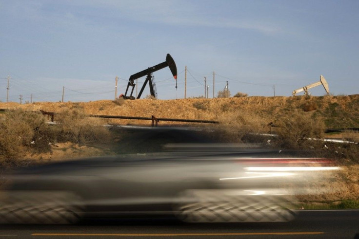 A car speeds past pump jacks on an oil field near Bakersfield, California January 18, 2015. REUTERS/Lucy Nicholson