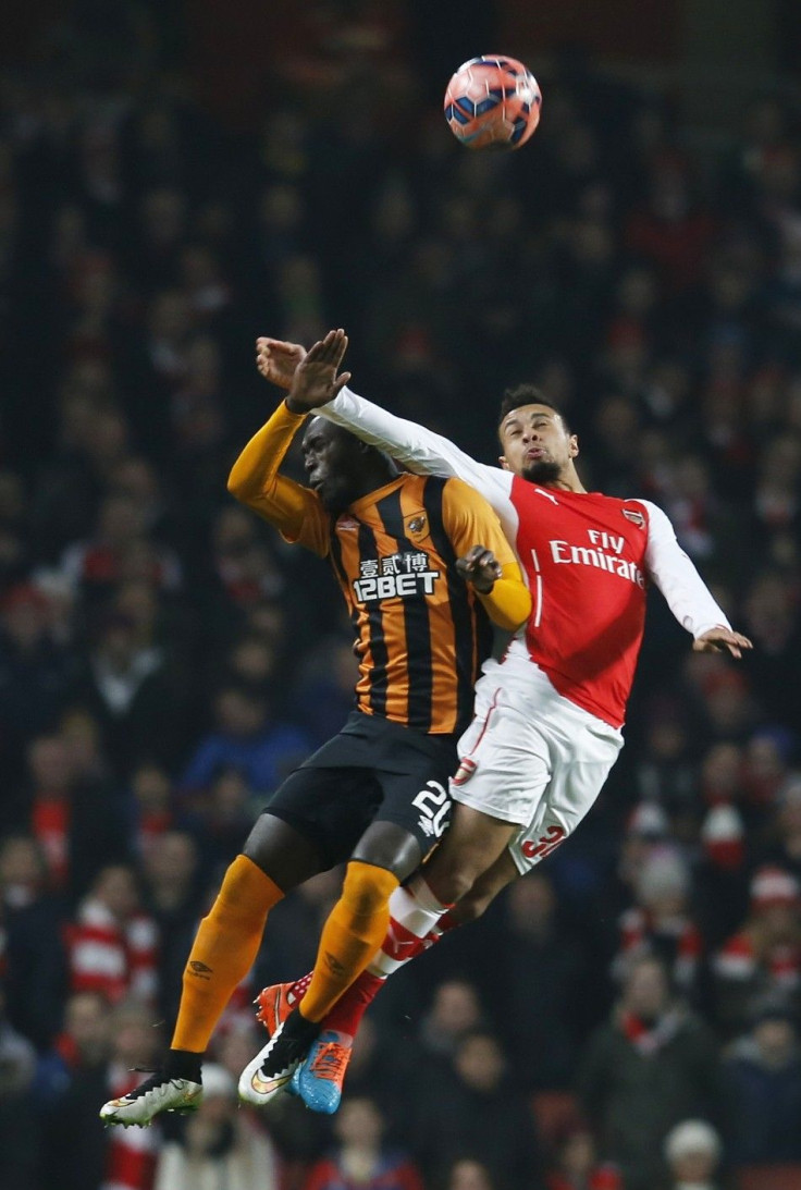 Francis Coquelin (R) of Arsenal and Yannick Sagbo of Hull jump for the ball during their FA Cup third round soccer match at the Emirates Stadium in London, January 4, 2015.