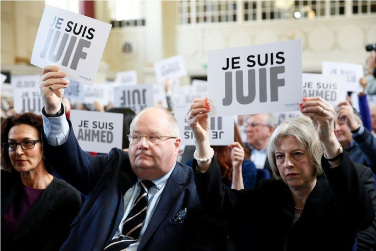Britain&#039;s Secretary of State for Communities Eric Pickles and Home Secretary Theresa May hold up signs reading &quot;I am Jewish&quot;