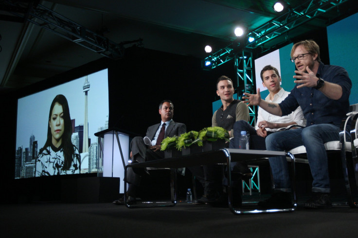 Actor Tatiana Maslany (L-R) appears on a screen as she joins senior vice president of programming Richard De Croce, actors Jordan Gevaris, Ari Millen, and co-creator, director and executive producer John Fawcett in the BBC America "Orphan Black" panel