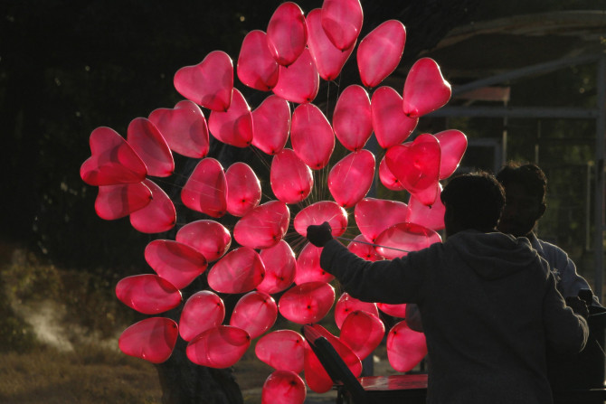 A man is silhouetted as he fills heart shaped balloons with helium while waiting for customers on Valentine's Day in Islamabad February 14, 2012.    