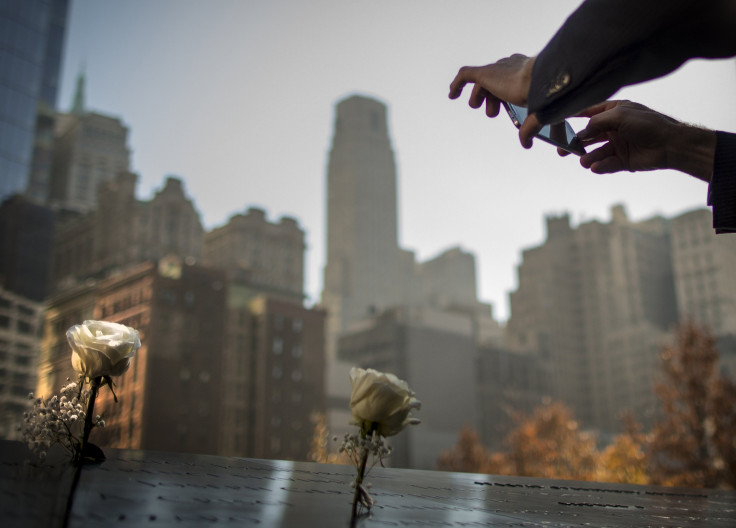 A man takes a picture of a flower placed on a name at the 9/11 Memorial in New York November 10, 2014. The 9/11 Memorial is holding a Salute to Service, a five day tribute to veterans for Veterans Day. 