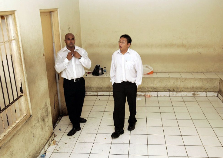 Australians Andrew Chan (R) and Myuran Sukumaran wait in a holding cell at a Denpasar court on the Indonesian resort island of Bali February 14, 2006. Both men were sentenced to death for drug trafficking.