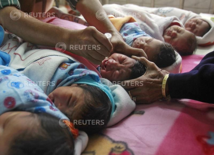 A medical worker administers polio drops to an infant at a hospital during the pulse polio immunization programme