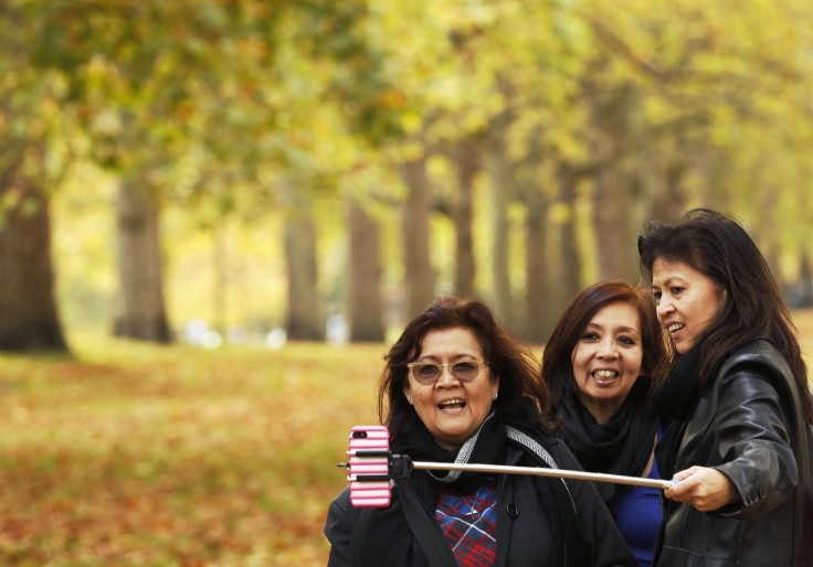 Visitor photograph themselves with autumn leaves in St James's Park in London October 17, 2014.