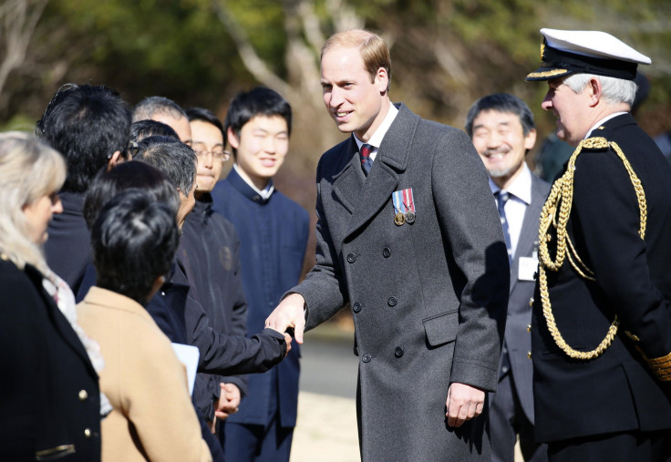 Britain's Prince William, Duke of Cambridge, talks with officials at Hodogaya Commonwealth War Graves Cemetery in Yokohama