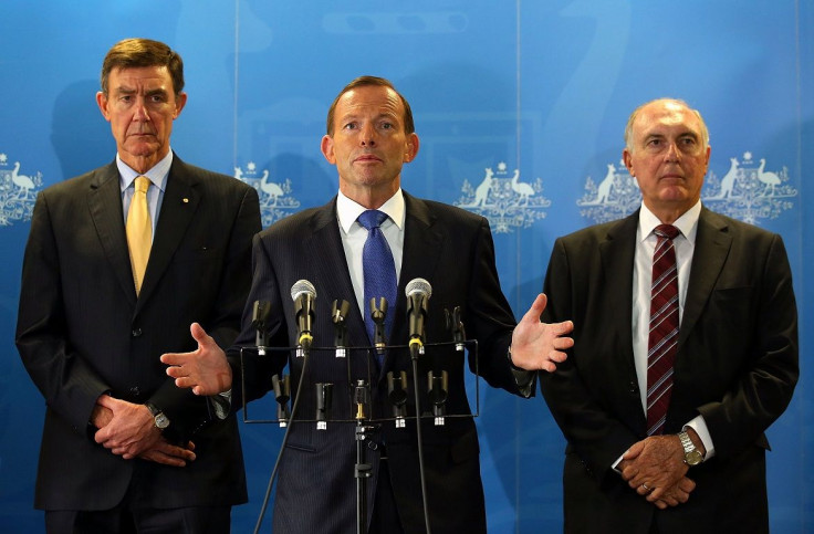 Australian Prime Minister Tony Abbott (C) speaks as former Australian Defence Force Chief Air Chief Marshal Angus Houston (L) and Deputy Prime Minister Warren Truss