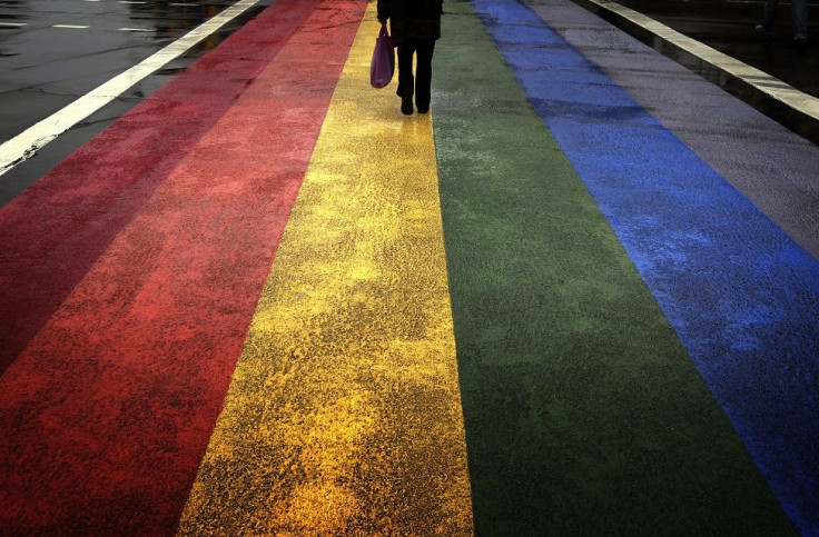 A pedestrian walks across a rainbow pedestrian crossing painted on Sydney's Oxford street, the city's main gay district April 4, 2013.