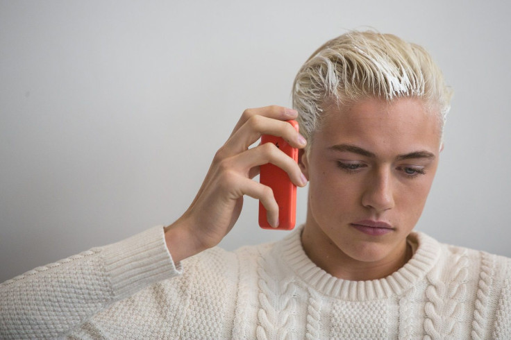 A model talks on his cell phone backstage before the Jeremy Scott Fall/Winter 2015 collection presentation at New York Fashion Week February 18, 2015.