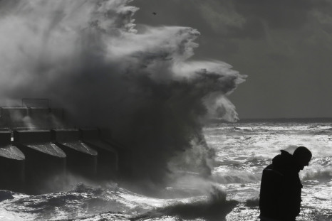 A man watches stormy seas in strong winds