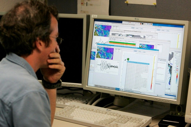 An oceanographer studies computer graphs regarding tsunami warnings near Papua New Guinea