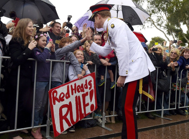 Britain's Prince Harry reacts with members of the public displaying a sign reading 'Red Heads Rule' after visiting the Australian War Memorial in Canberra April 6, 2015.