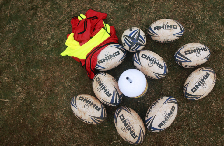 Rugby balls lying on the ground during a training session.