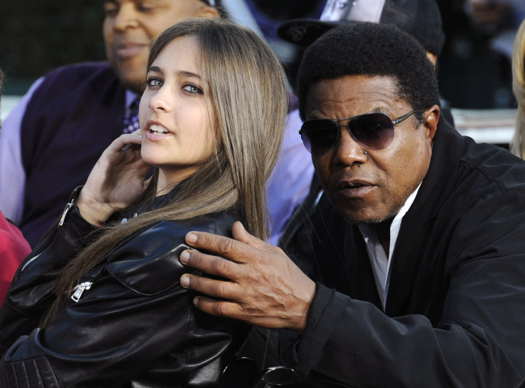 [9:35] Michael Jackson's daughter Paris (L) and brother Tito Jackson share a moment at a ceremony where the singer is immortalized with hand and foot imprints 