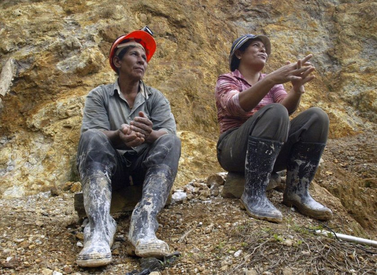 Two women rest outside the tunnel entrance of the Santa Elena mine after putting in their day's work, December 5, 2006.