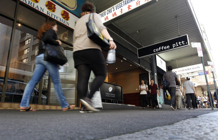 Pedestrians walk past a coffee shop in Sydney 