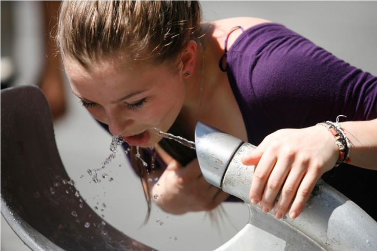 A Woman Drinks From a Fountain