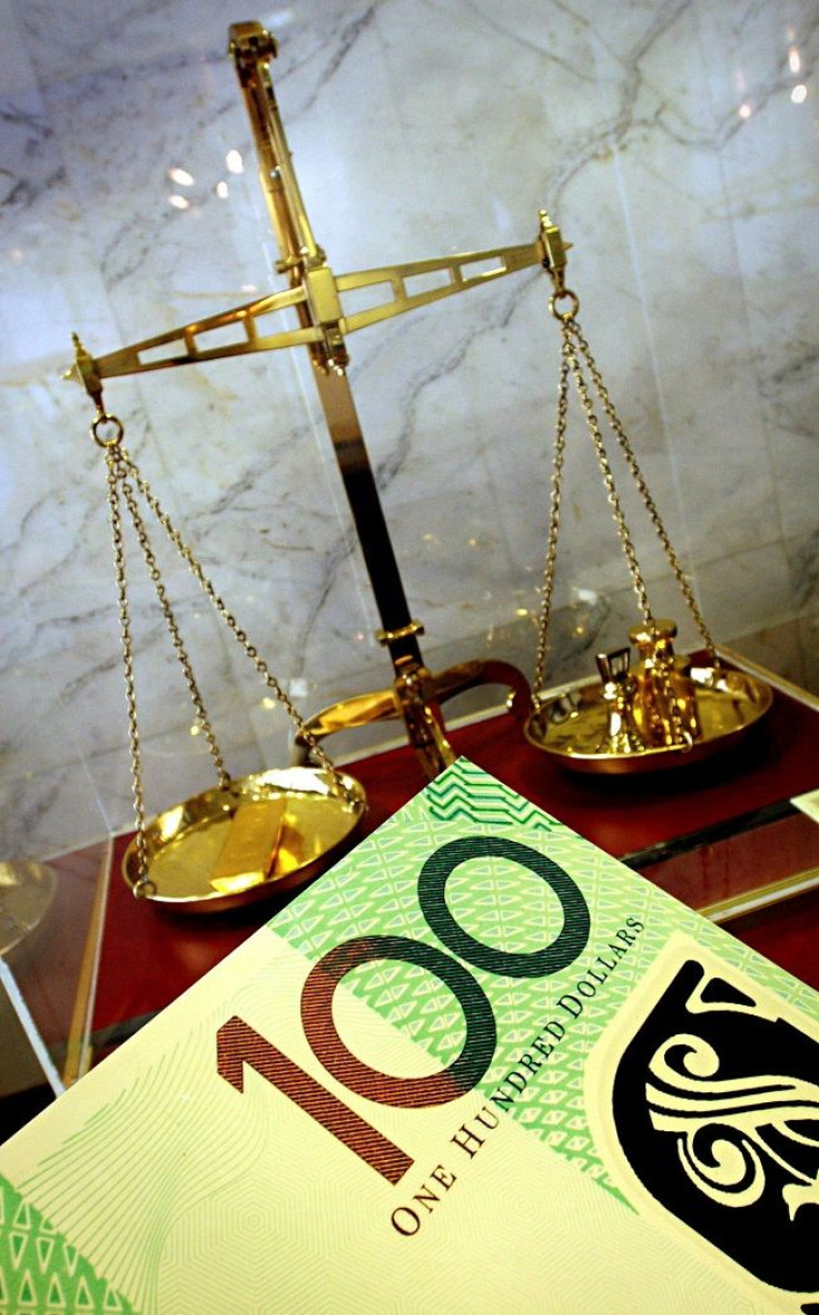 An Australian $100 note and a set of gold measuring scales form part of a public display at the Reserve Bank of Australia office in Sydney January 16, 2003.