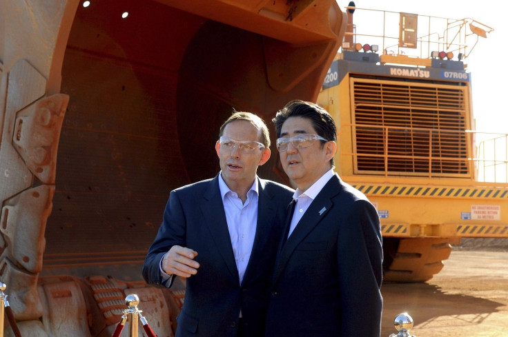 Australian Prime Minister Tony Abbott and his Japanese counterpart Shinzo Abe talk next to a loader bucket during a tour of the Rio Tinto West Angelas iron ore mine in the Pilbara region of Western Australia, July 9, 2014.