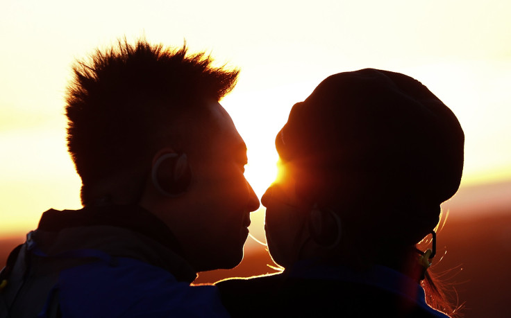 A mandarin-speaking couple kiss at sunrise