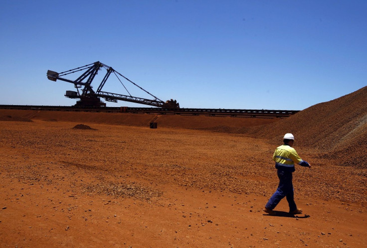 A worker walks past a bucket-wheel reclaimer at the Fortescue loading dock located at Port Hedland in the Pilbara region of Western Australia December 3, 2013.