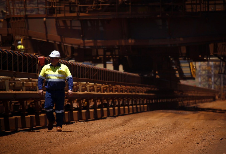 A worker walks near conveyer belts loaded with iron ore at the Fortescue Solomon iron ore mine located in the Valley of the Kings, around 400 km (248 miles) south of Port Hedland in the Pilbara region of Western Australia December 2, 2013.