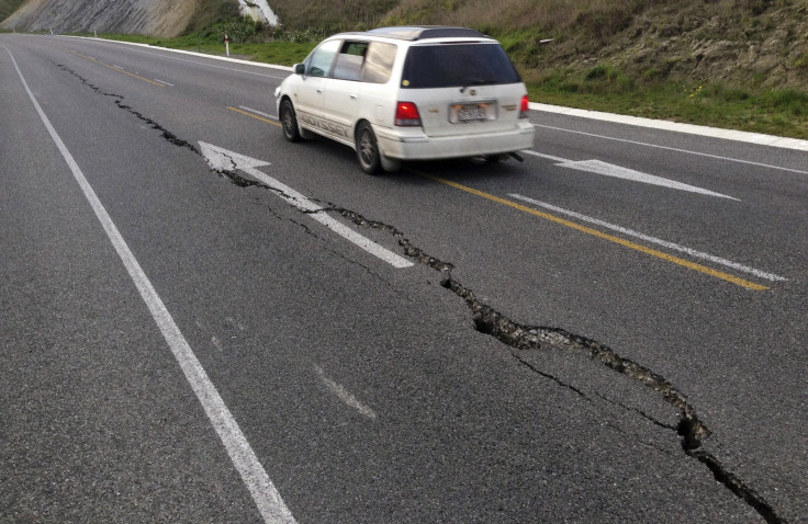 A car drives past a crack in a road in Seddon, New Zealand