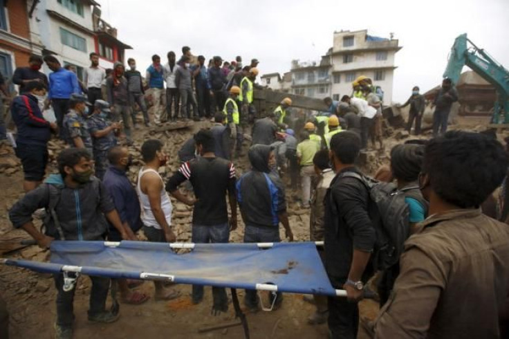 Rescue workers search for bodies as a stretcher is kept ready after an earthquake hit, in Kathmandu, Nepal. 