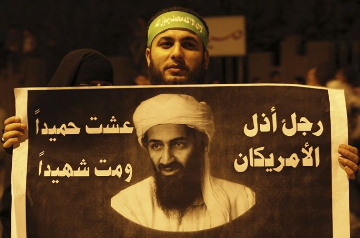A couple of Islamist protesters hold up a poster with a picture of Osama bin Laden