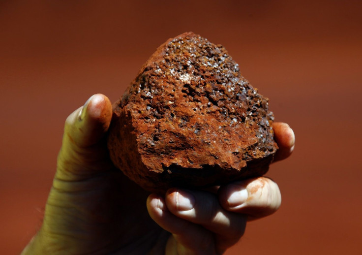 A miner holds a lump of iron ore at a mine located in the Pilbara region of Western Australia December 2, 2013.