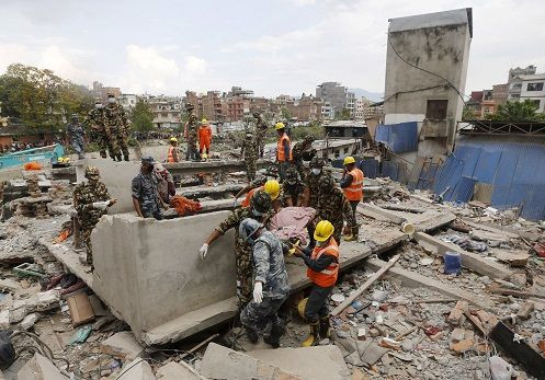 India's National Disaster Response Force (NDRF) personnel and Nepal army soldiers carry a body