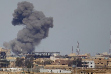 A plume of smoke rises above a building during an air strike 